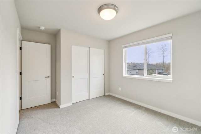 unfurnished bedroom with a closet, baseboards, and carpet floors