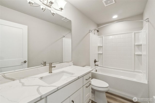 bathroom with visible vents, toilet, wood finished floors, tub / shower combination, and vanity