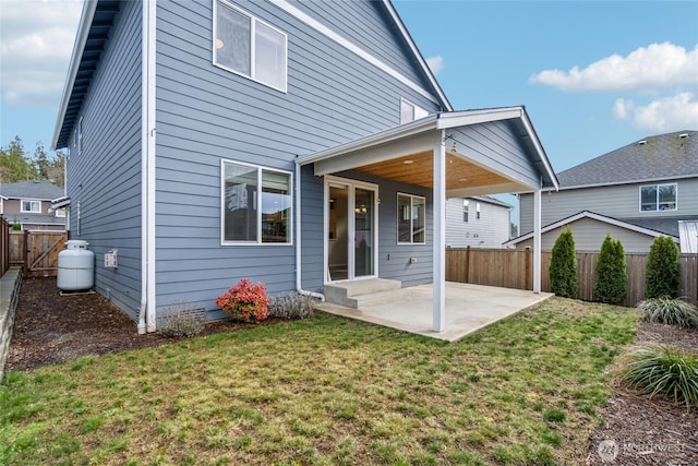 back of house with a patio, a lawn, and a fenced backyard