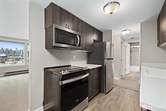 kitchen featuring stainless steel appliances, baseboard heating, dark brown cabinets, and light countertops