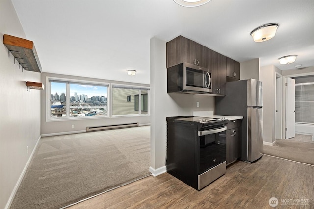 kitchen featuring dark brown cabinets, baseboards, a city view, baseboard heating, and stainless steel appliances