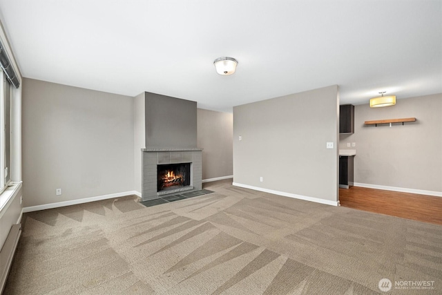 unfurnished living room with a fireplace with flush hearth, baseboards, and carpet floors