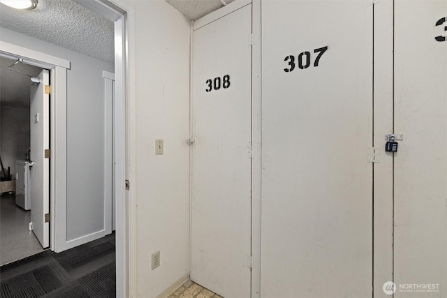 hallway with a textured ceiling