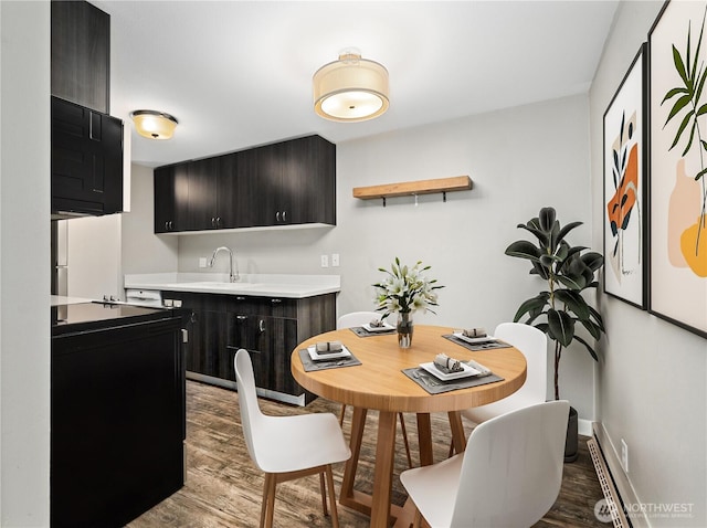 dining area with baseboards and wood finished floors