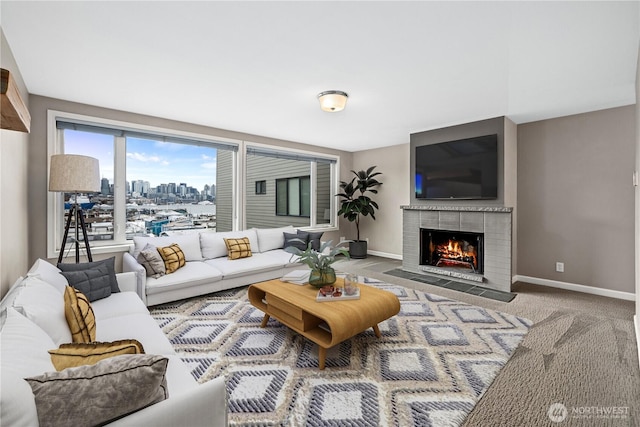 carpeted living area featuring baseboards and a tile fireplace