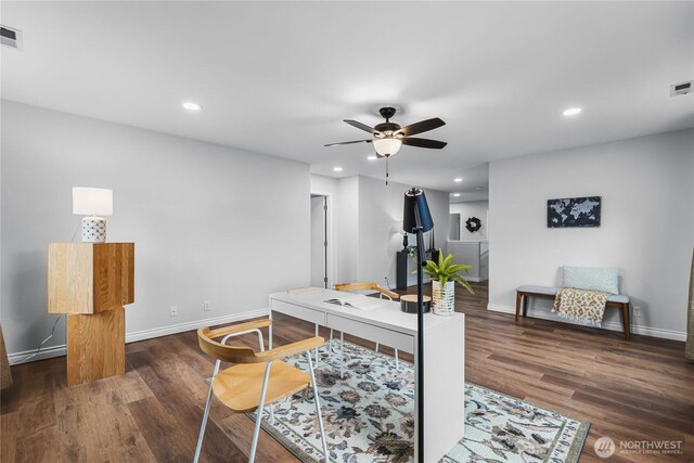 home office with visible vents, baseboards, ceiling fan, and dark wood-style flooring