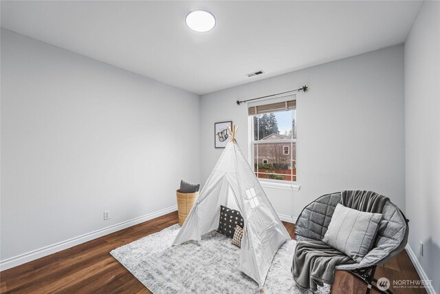 playroom featuring dark wood-style floors, visible vents, and baseboards