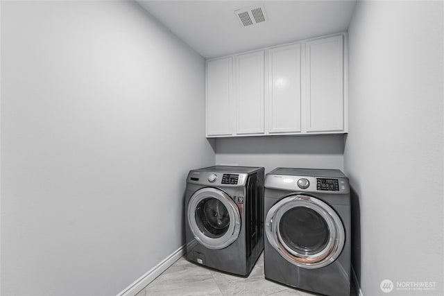 washroom featuring washer and dryer, visible vents, cabinet space, and baseboards