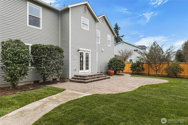 rear view of house with a patio area, a lawn, french doors, and fence