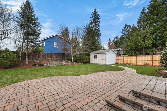 view of patio / terrace with an outdoor structure, a storage unit, and a fenced backyard