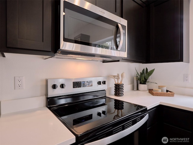 kitchen with stainless steel microwave, light countertops, and range with electric stovetop