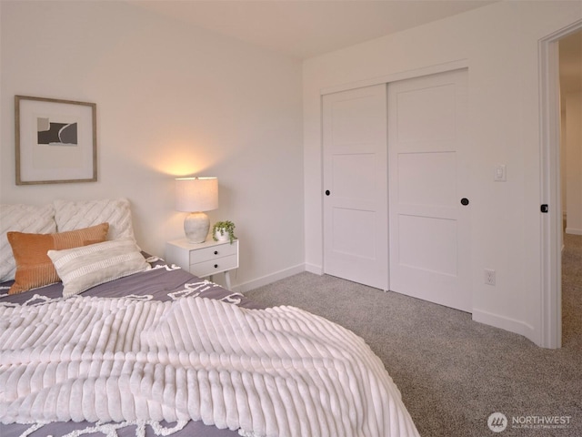 carpeted bedroom with a closet and baseboards