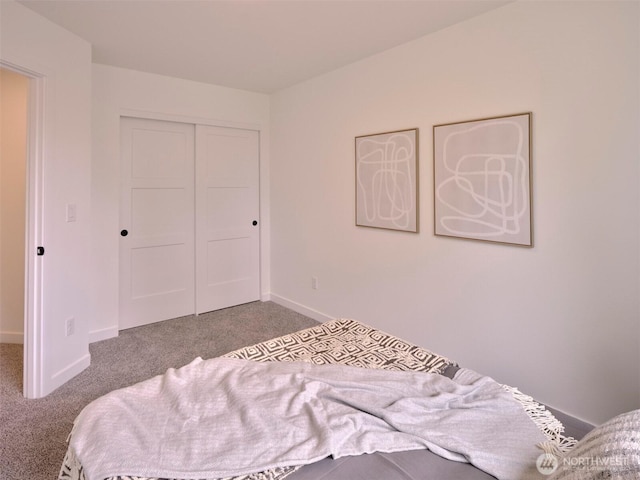 bedroom with a closet, baseboards, and carpet floors