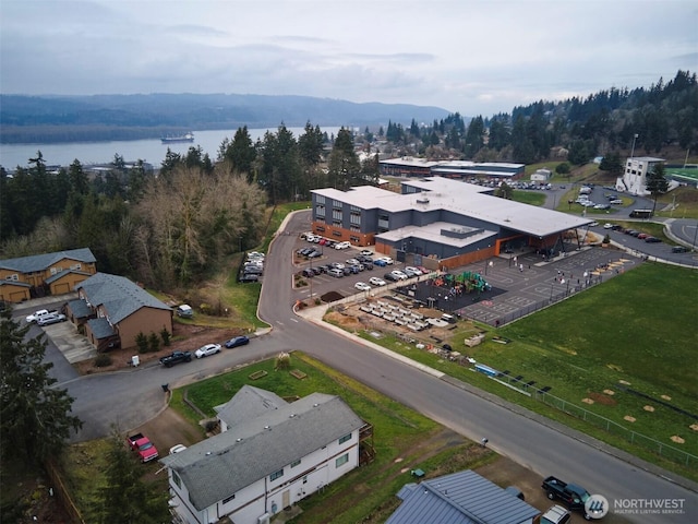 aerial view featuring a forest view and a water view