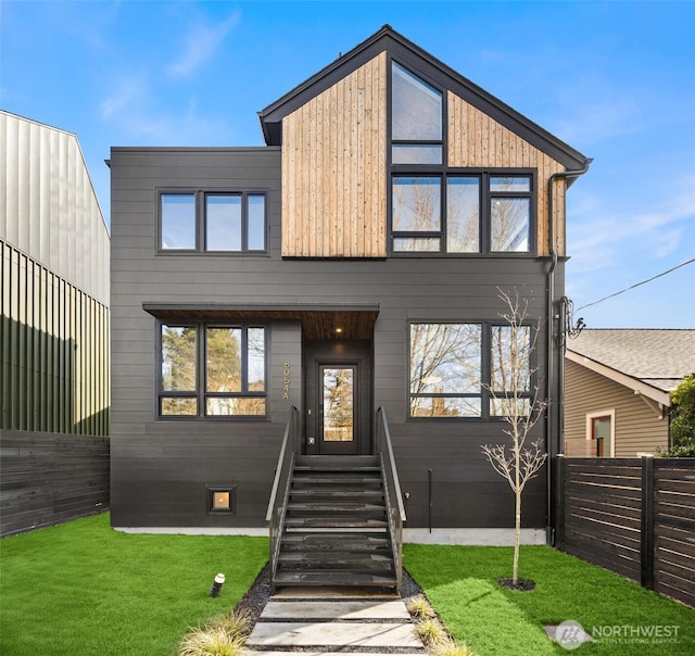 modern home with a front yard and fence