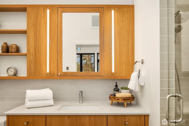 full bathroom with visible vents, tiled shower, backsplash, and vanity