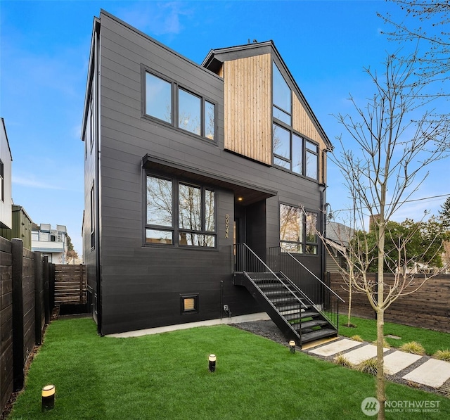 modern home with a fenced backyard and a front lawn