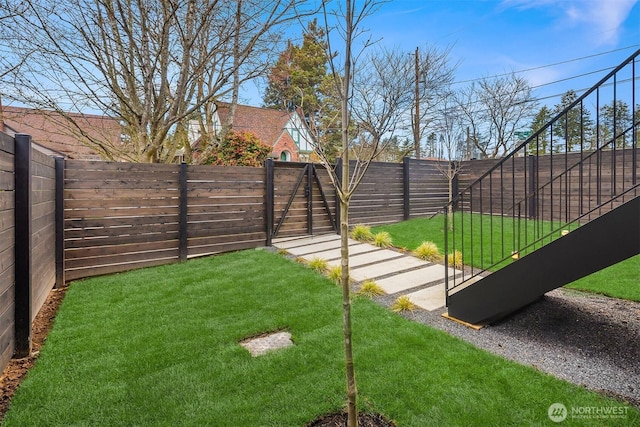 view of yard with a fenced backyard and a gate