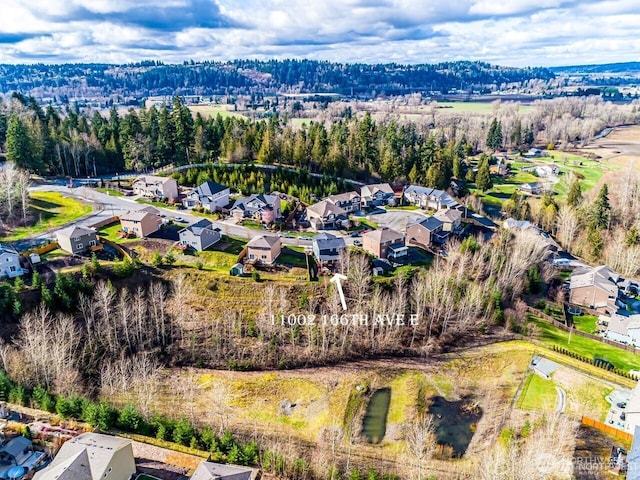 birds eye view of property featuring a residential view and a wooded view