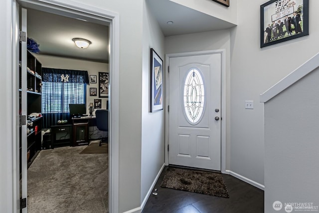 entryway with plenty of natural light, baseboards, and dark colored carpet