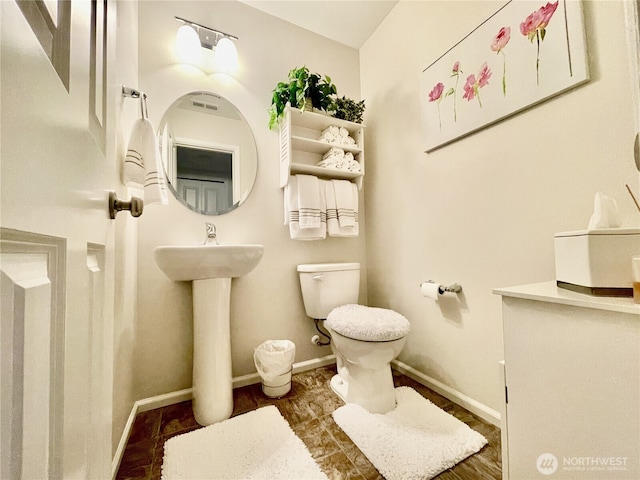 bathroom with toilet and baseboards