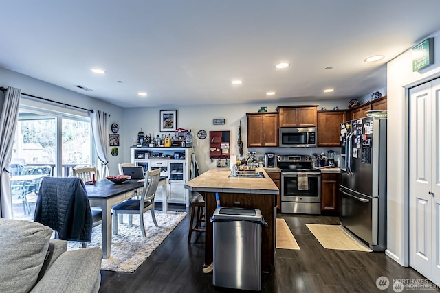 kitchen featuring visible vents, a kitchen breakfast bar, recessed lighting, appliances with stainless steel finishes, and dark wood-style flooring