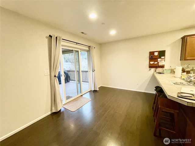 unfurnished dining area with dark wood finished floors, visible vents, recessed lighting, and baseboards