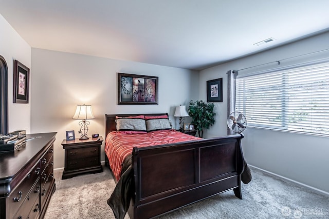 bedroom with visible vents, baseboards, and light colored carpet