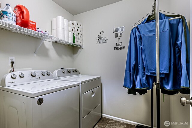 clothes washing area featuring baseboards, washing machine and dryer, and laundry area