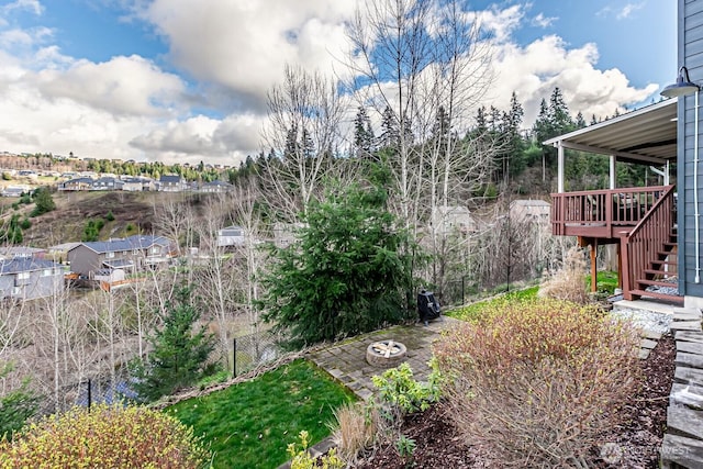 view of yard with a deck, stairs, and fence