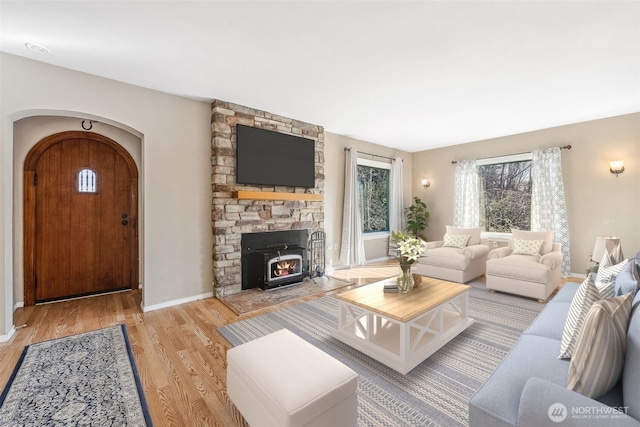 living room with baseboards, arched walkways, and wood finished floors