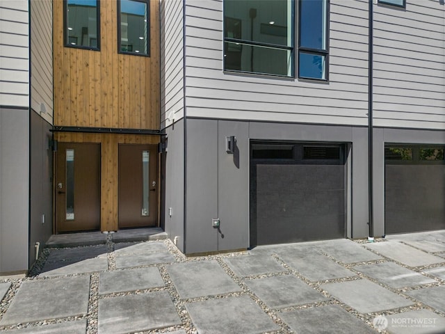 doorway to property featuring concrete driveway and an attached garage