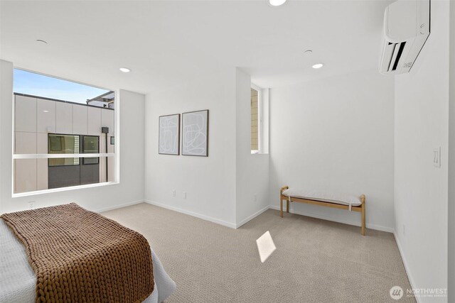 bedroom with recessed lighting, baseboards, light colored carpet, and a wall unit AC