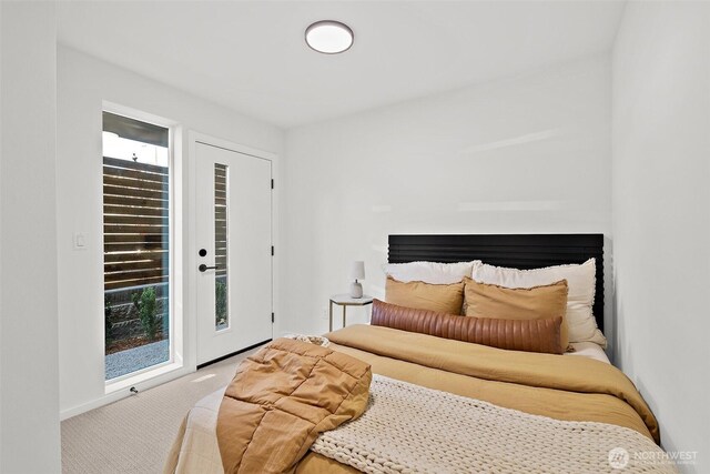 carpeted bedroom with access to outside and baseboards