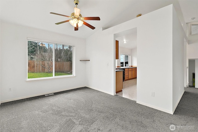 interior space featuring visible vents, baseboards, light colored carpet, and ceiling fan