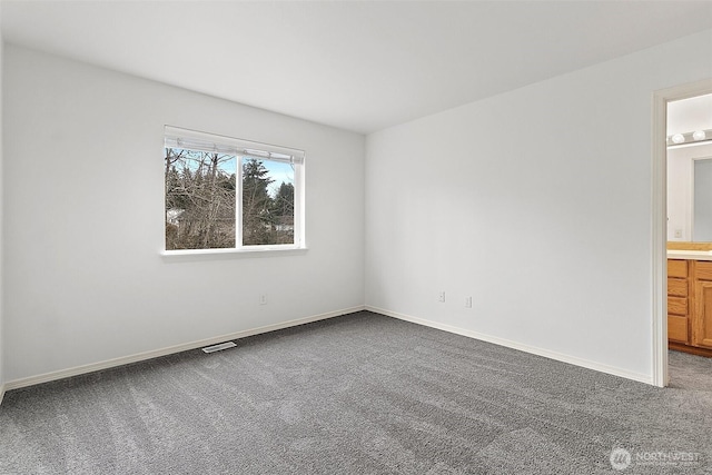 carpeted spare room featuring visible vents and baseboards