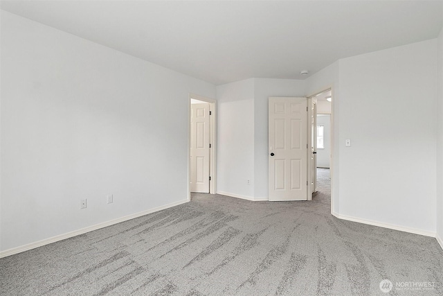 empty room featuring baseboards and carpet floors