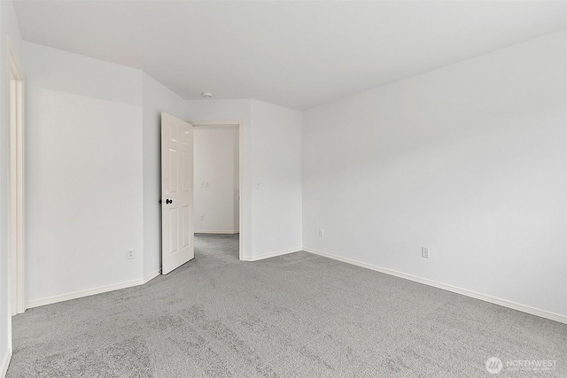 spare room with baseboards and carpet