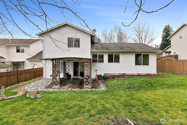 rear view of house featuring a patio, a yard, and a fenced backyard