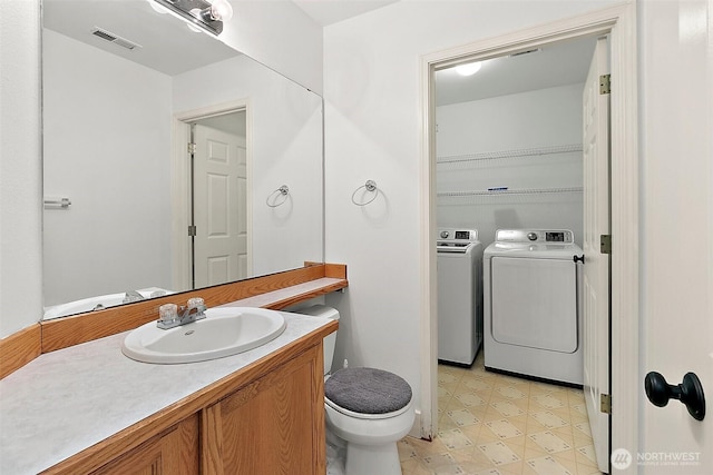 bathroom featuring visible vents, washer and clothes dryer, toilet, tile patterned floors, and vanity