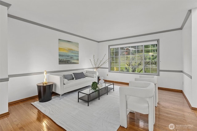 living room with wood finished floors, baseboards, and ornamental molding