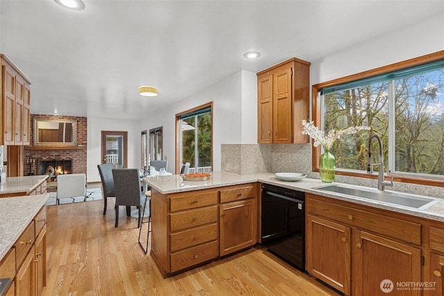 kitchen featuring a sink, plenty of natural light, black dishwasher, and a peninsula