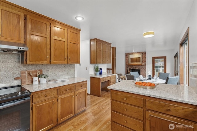 kitchen featuring under cabinet range hood, brown cabinetry, and black range with electric stovetop