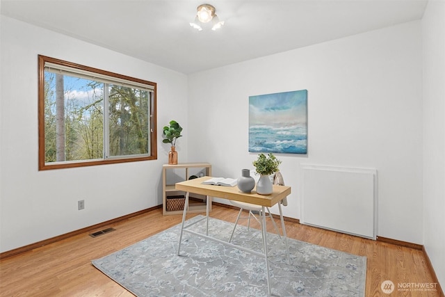 office area featuring visible vents, baseboards, and wood finished floors