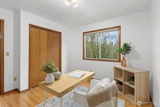 office space featuring baseboards and light wood-type flooring