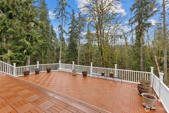 wooden terrace featuring a view of trees