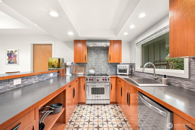 kitchen with appliances with stainless steel finishes, wall chimney exhaust hood, stainless steel countertops, and a sink