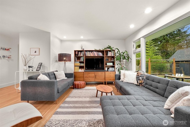 living room with recessed lighting, baseboards, and wood finished floors