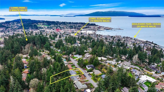 birds eye view of property with a water and mountain view