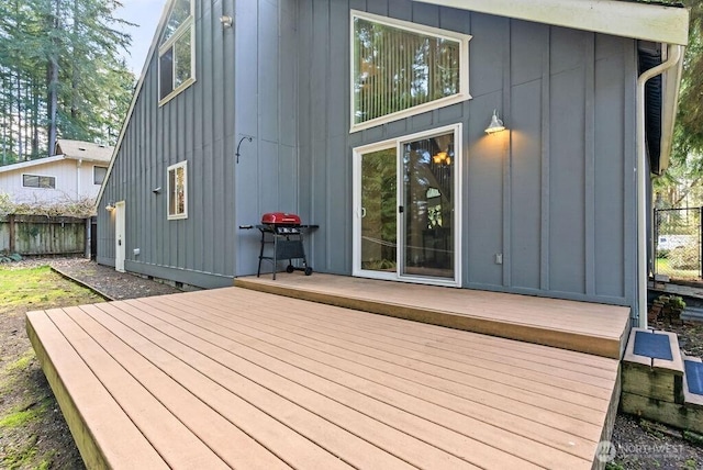 wooden terrace featuring area for grilling and fence